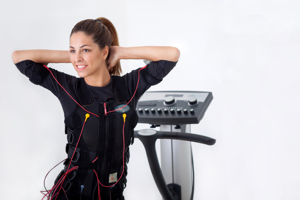 young fit woman exercise on electro muscular stimulation machine